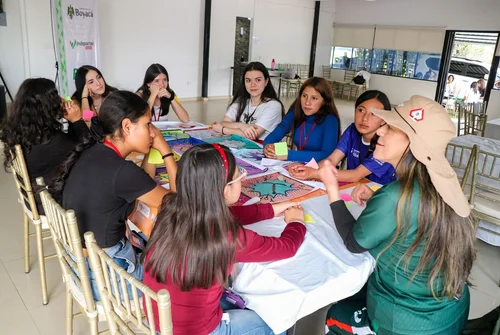 Jóvenes guardianas reunidas en formación alrededor de una mesa de trabajo